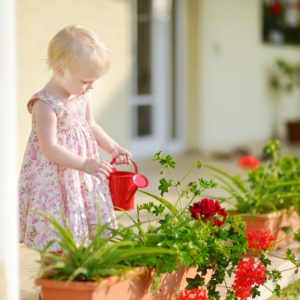 Cute little girl watering flowers