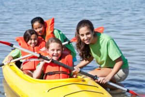 Family enjoying kayaking at summer camp