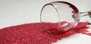 Person cleaning food stain from cloth sofa using mild detergent and cloth