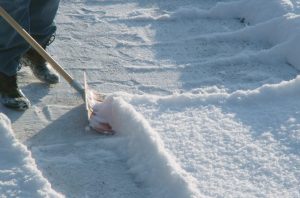 Winter service clearing snow from a parking lot with snow plow and salt spreader.