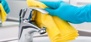 Cleaning a stainless steel kitchen sink with sponge and detergent