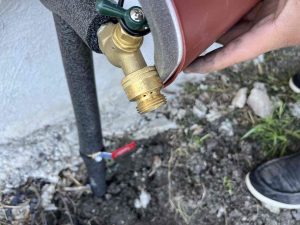 Plumber insulating pipes to prevent freezing in winter.