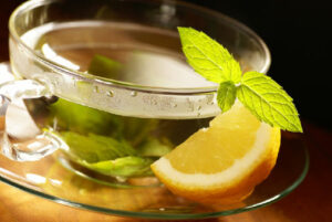 Lemon water in a glass representing a natural first aid remedy for digestion, immunity, and hydration.