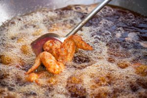 Grease being poured into a kitchen sink drain