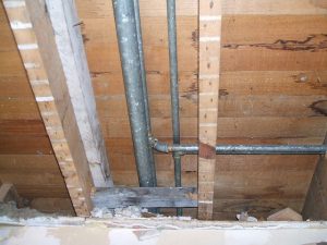 Hidden water damage behind wall paint with mold and peeling surface.