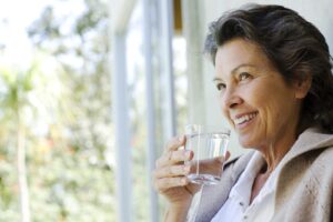 Woman drinking filtered water at home