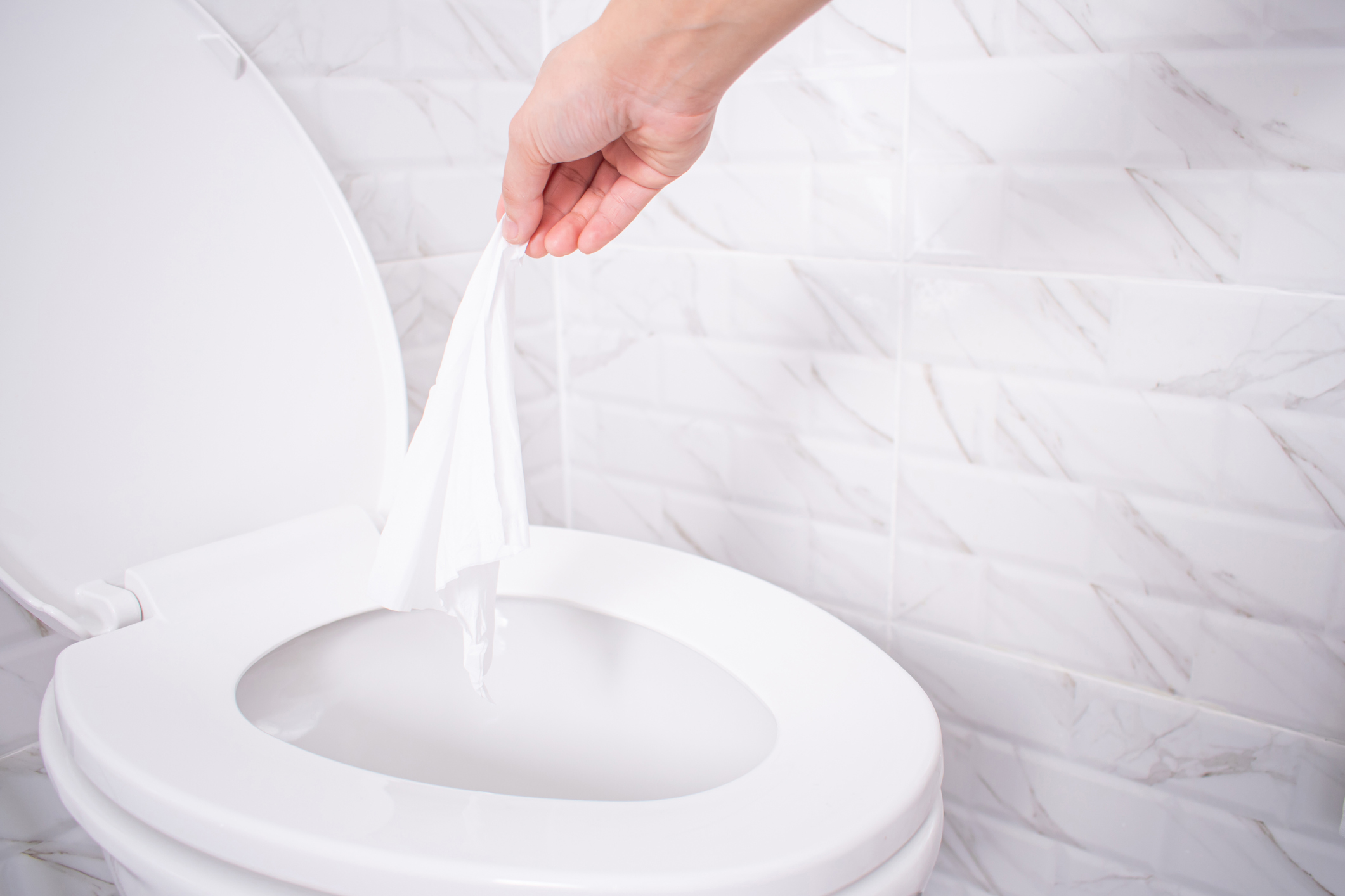 Flushable wipes being flushed down a toilet.